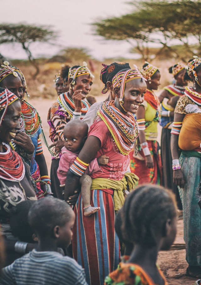 Maman kenyane en habits traditionnels portant son enfant sur le dos, symbole de lien humain et de voyage immersif et sur-mesure.