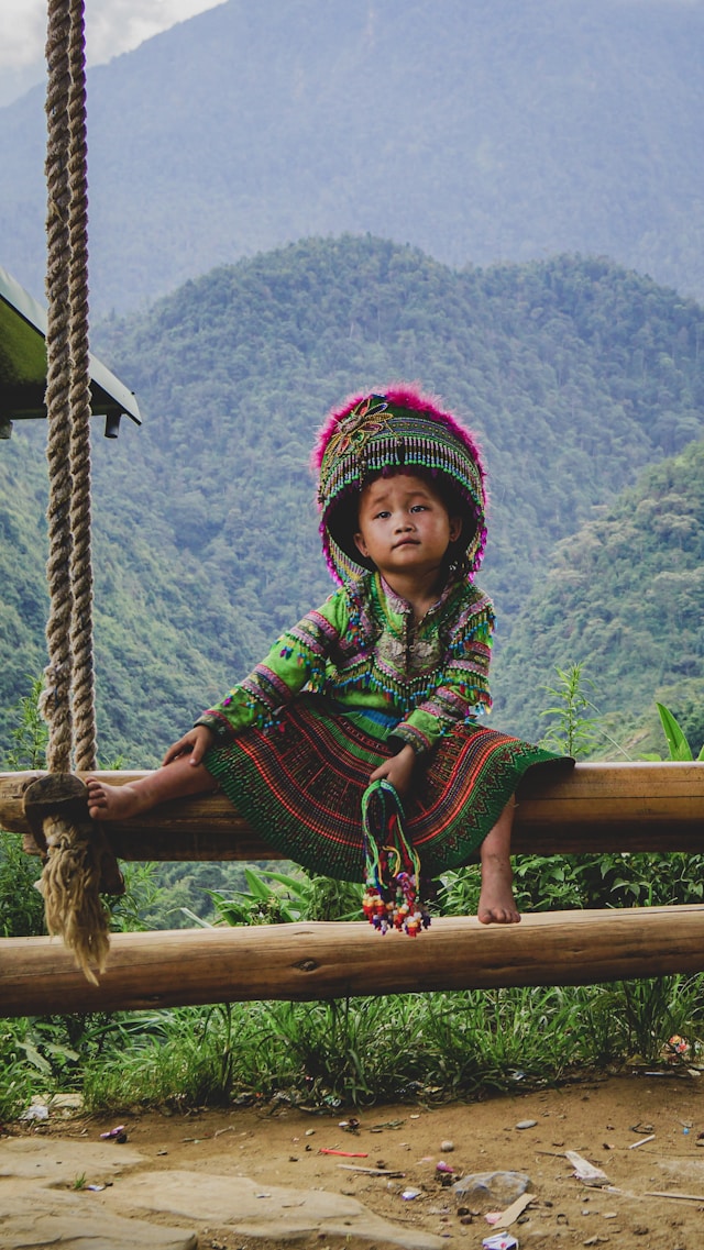 Petite fille en habits traditionnels au Vietnam, symbole d’un long voyage immersif à la rencontre des cultures locales. 100% sur-mesure.